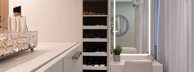 Penteadeira planejada com espelho iluminado e closet com nichos para calçados