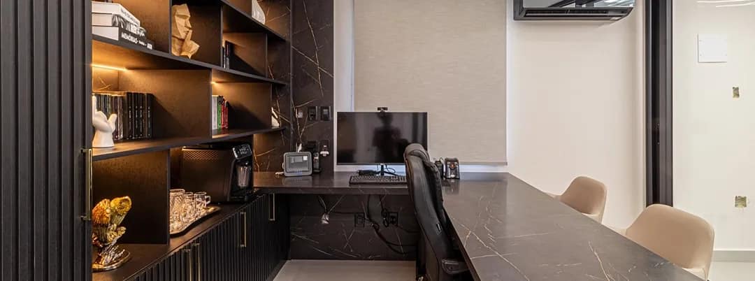 Home office planejado com estante iluminada e bancada